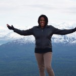 Brooke Obie stands on top of a mountain range in Alaska near winterlake lodge